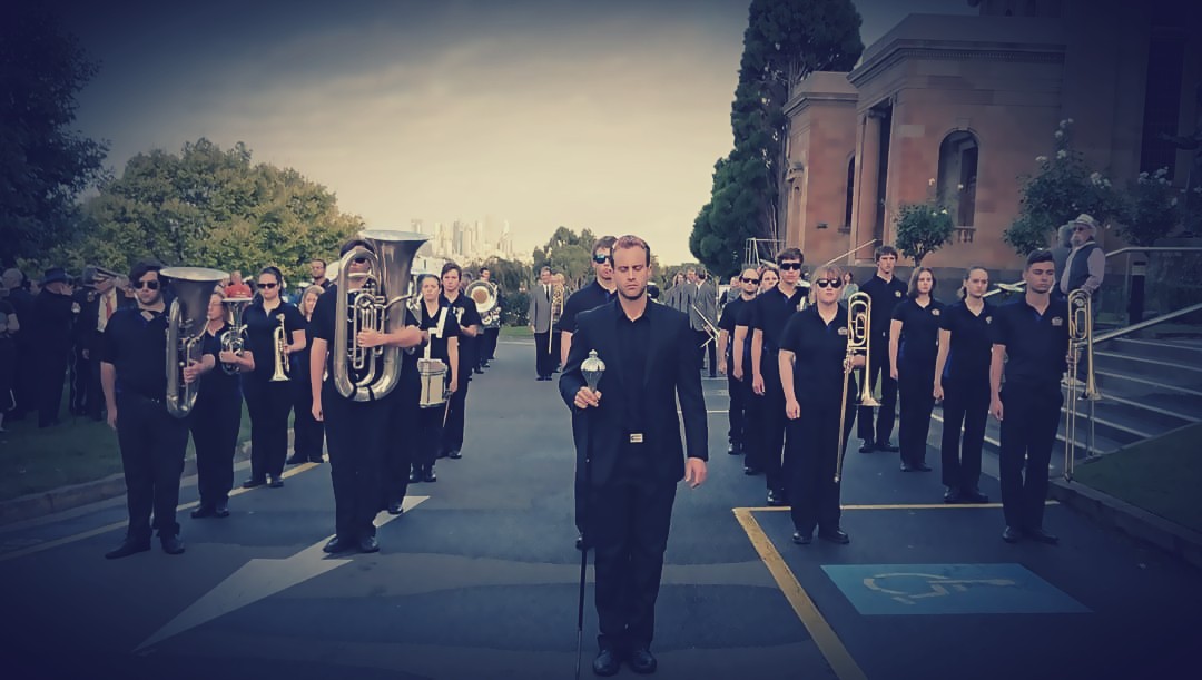 Hobart City Brass Band members marching, with Dan Brown at the front.